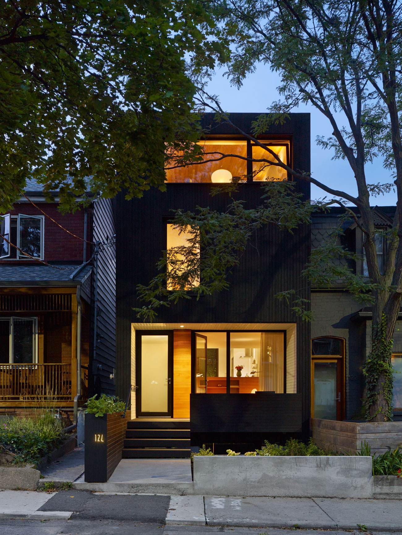 Black wood siding covers the exterior of the modern urban home - Great Lake Studio  design by Great Lake Studio