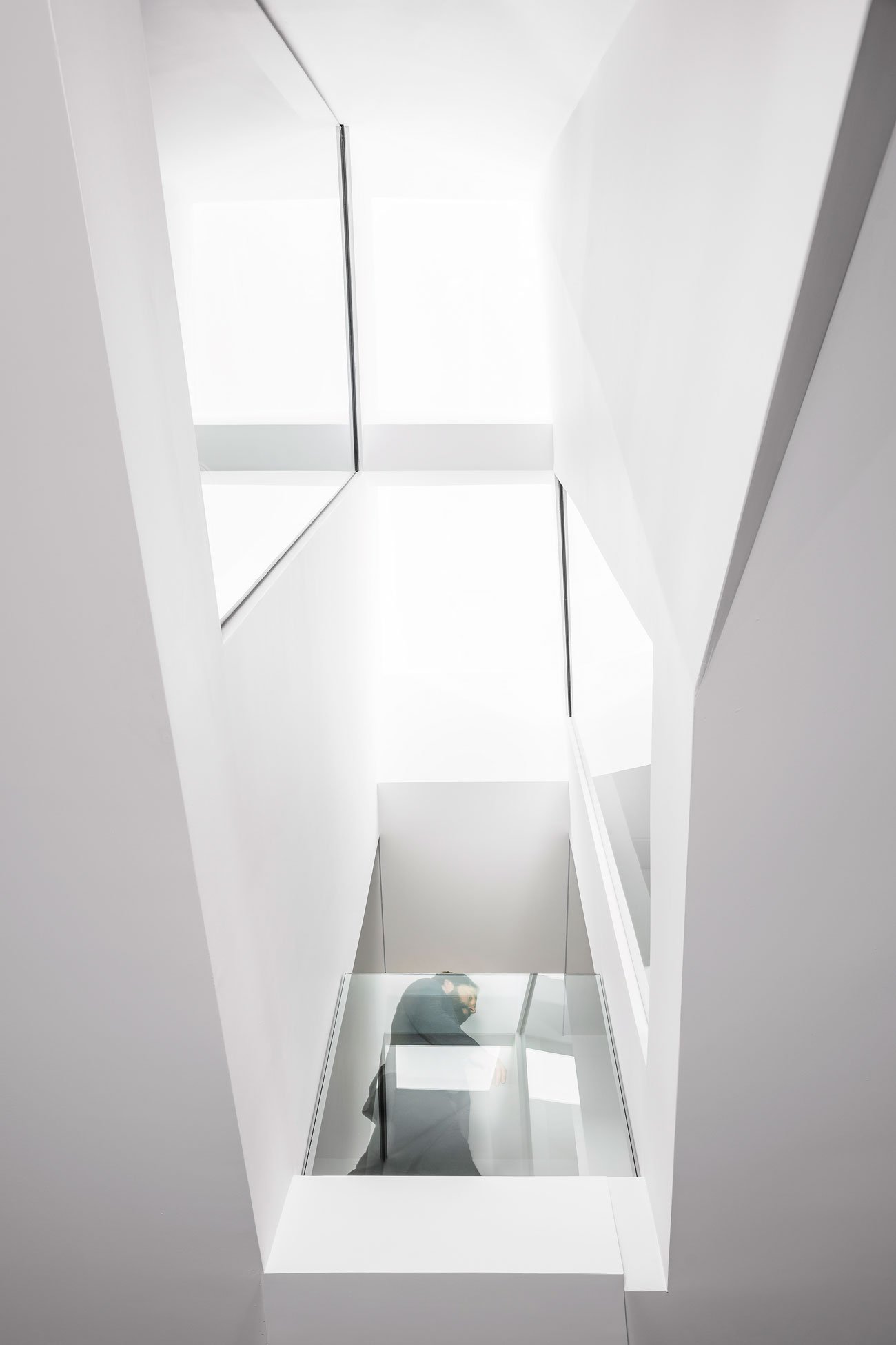 Staircase landing with views up to a Velux skylight, down to the first floor, and across to two staggered interior windows.
