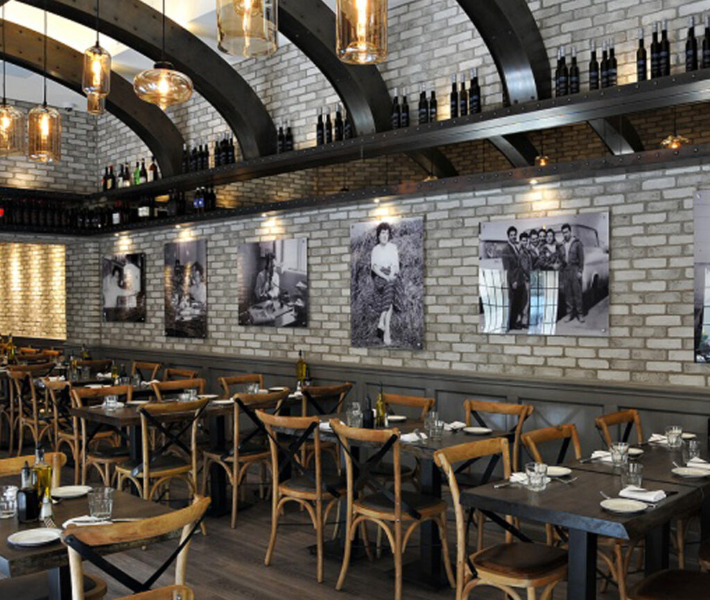 Century Architecture restaurant interior with grey brick wall coverings and dark wood tables and chairs