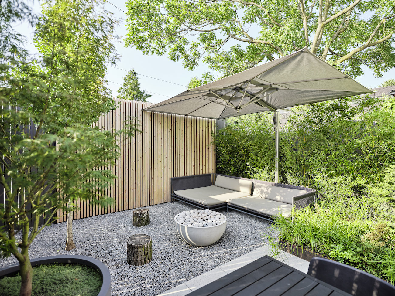 Seating area in a small garden with pea gravel.